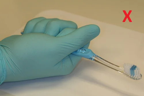 Dentist showing how not to hold a toothbrush