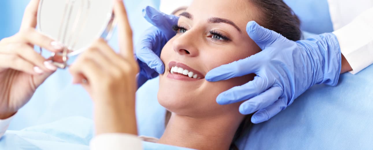 Dentist shows patient the results of her smile makeover