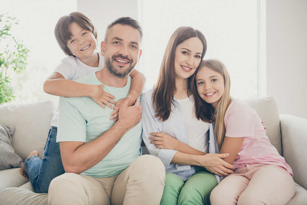 Family of four with beautiful teeth showing the importance of general dentistry